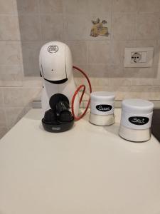 a coffee maker sitting on a counter with two cups at King house in Sanremo