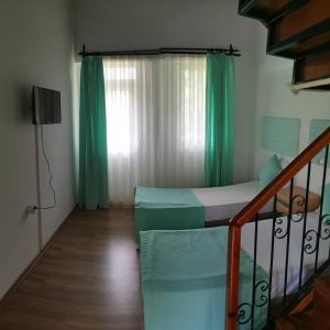 a bedroom with a bed and a window with green curtains at Balkaya Hotel in Oludeniz