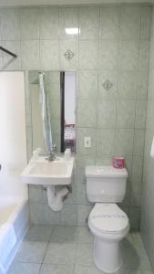 a bathroom with a white toilet and a sink at Eagle Rock Motel in Los Angeles