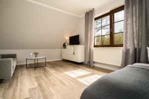 a bedroom with a bed and a table and a window at Reetdachhotel - Residenz am Ostufer in Boek