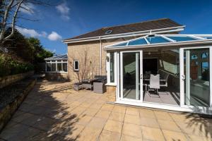 a conservatory with a glass door on a patio at Sea La Vie in Carbis Bay