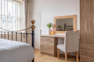 a bedroom with a desk with a mirror and a bed at Central Kendal Retreat - Work or Holiday friendly in Kendal