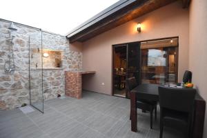 a dining room with a table and a glass shower at Villa ANTONA in Prkos