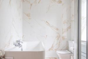 a white bathroom with a sink and a toilet at Central Kendal Retreat - Work or Holiday friendly in Kendal