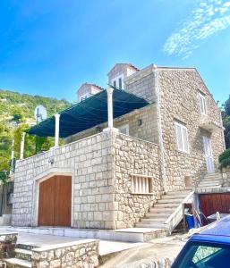 a stone house with a garage and a roof at Beach house Evita in Prožura