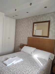 a bedroom with a bed with a mirror on the wall at La Colina - Playamar Apartamento in Torremolinos