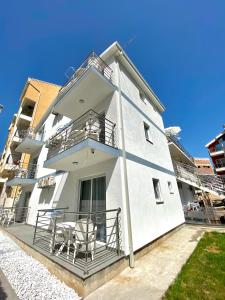 a white building with two chairs on the balcony at Apartments Monika in Budva