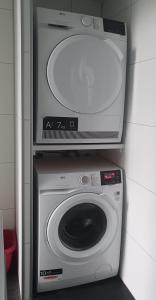 a washing machine with a tv on top of it at Klein Ramdal in Putten