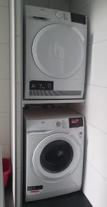 a washing machine with a tv on top of it at Klein Ramdal in Putten +4 photos
