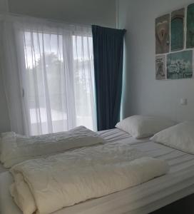 a bedroom with a large bed with a window at Klein Ramdal in Putten