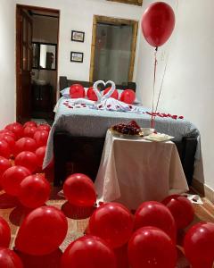 a group of red balloons in a room with a bed at Finca Hotel Cabaña Fercho in Quimbaya