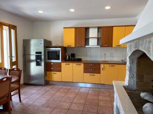 a kitchen with yellow cabinets and a stainless steel refrigerator at Beach house Evita in Prožura