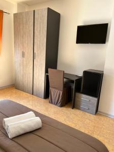 1 dormitorio con escritorio, TV y cama en Oasi B&B hotel Restaurant, en Cerignola