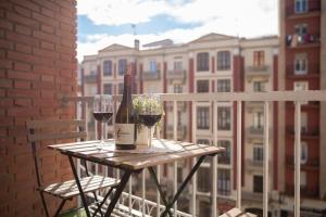 un tavolo con due bicchieri di vino sul balcone di Apartamento Logroño Plaza Ayuntamiento a Logroño