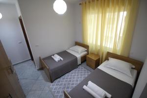 una piccola camera con due letti e una finestra di Sunrise Apartment a Sarandë