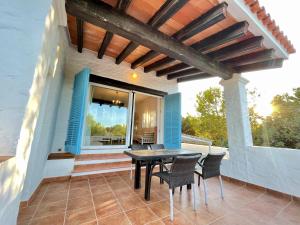 een patio met een tafel en stoelen op een huis bij Casa El Torreón in Es Pujols