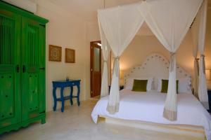 a bedroom with a white bed with a canopy at Coco Hacienda Tulum - Adults Only in Tulum