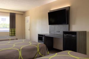 Televízia a/alebo spoločenská miestnosť v ubytovaní Super 8 by Wyndham McDonough GA