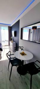 mesa blanca y sillas en una habitación con mesa y mesa en Apartament Golden Loft Studio Planeta Mielno - 100m od plaży, en Mielno