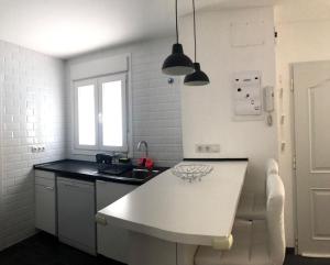 a kitchen with a white table and a sink at La Casita in Málaga