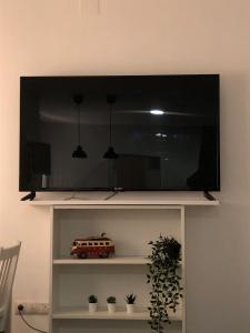 einen Fernseher auf einem Regal mit Spielzeugauto drauf in der Unterkunft La Casita in Málaga