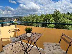 a wooden table and two chairs on a balcony at Ferienwohnung Auersbergblick in Schönheide