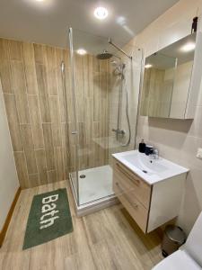 a bathroom with a shower and a sink and a mirror at Siguldas apartment in Liepāja +2 photos
