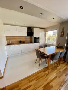 a kitchen and dining room with a table and chairs at Siguldas apartment in Liepāja