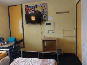 a room with a bed and a desk and a tv at Basildon House in Basildon