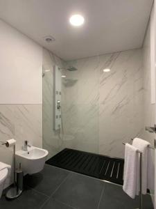 布拉加的住宿－PALHOTAS GUEST HOUSE - Suite Premium Bom Jesus，带淋浴和盥洗盆的白色浴室