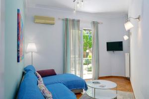 salon z niebieską kanapą i oknem w obiekcie Venias Two-Bedroom apartment Kallimarmaro and Zappeio area w Atenach