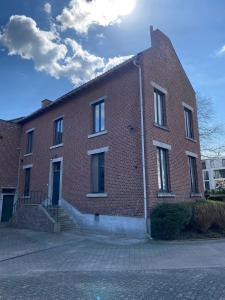 a red brick building with stairs on the side of it at Huis Louis in Kortessem