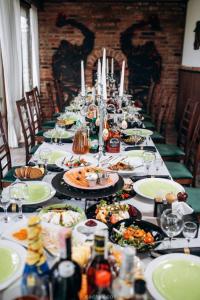 a dining room table filled with plates of food at Кузня міні-готель in Mateyevtsy