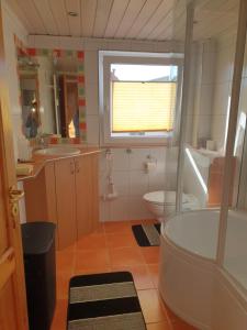 a bathroom with a tub and a toilet and a window at Hotel, Ferienwohnung, Zimmer in Bad Driburg