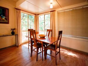 a living room with a wooden table and chairs at Noonameena Cottage in Halls Gap