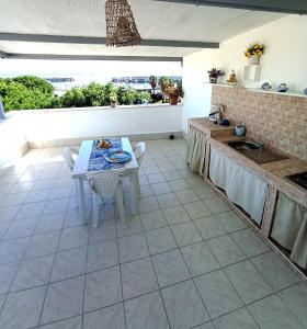 cocina con mesa, fregadero y encimera en Casa vacanze bluchic Gioisia, en Isola delle Femmine
