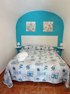 1 dormitorio con 1 cama con cabecero azul en Casa vacanze bluchic Gioisia, en Isola delle Femmine