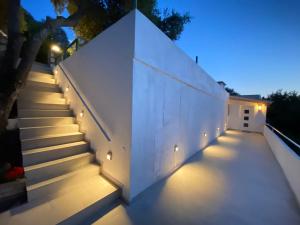 a staircase leading up to a white wall with lights at Alexander studio in Spartia