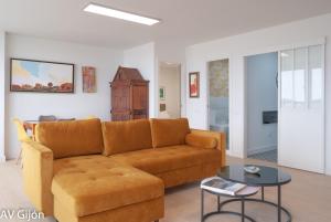ein Wohnzimmer mit einem Sofa und einem Tisch in der Unterkunft AV Gijón Emilio Tuya in Gijón