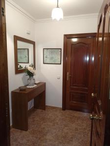 een kamer met een deur, een tafel en een spiegel bij Sandino 10 in Santiago de Compostela
