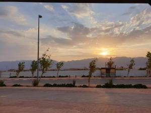 a sunset in a parking lot with a street light at סויטה בלב המדבר. in Beʼer Ora