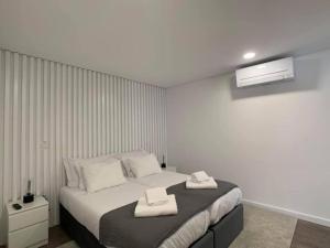 une chambre avec un lit avec deux serviettes dessus dans l'établissement PALHOTAS GUEST HOUSE - Apartamento Sameiro, à Braga