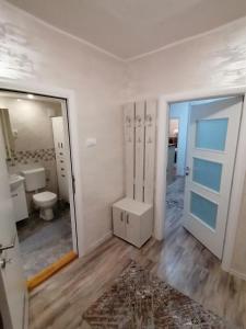 een badkamer met een toilet, een wastafel en een spiegel bij VEMIUR in Čačak