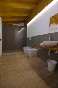 ein Badezimmer mit drei Waschbecken und zwei Toiletten in der Unterkunft Péstrofa in San Pietro al Natisone