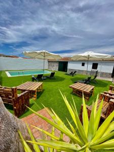 un resort con tavoli, ombrelloni e una piscina di Complejo Rural Rincón del Paraíso a Valencia del Mombuey