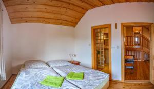 Un dormitorio con una cama con almohadas verdes. en SIKY-LIPTOV, en Liptovský Ján