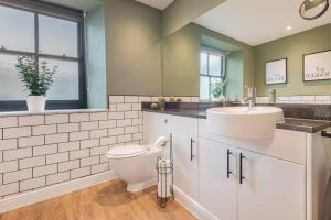 a bathroom with a toilet and a sink at Carpenters Cottage - The Lakes! in Kendal