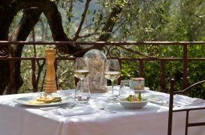 a table with wine glasses and a plate of food at Auberge De La Madone in Peillon