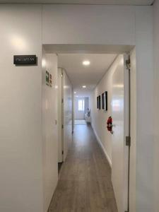een hal met witte muren en een lange hal met witte vloeren bij PALHOTAS GUEST HOUSE - Apartamento Palhotas in Braga