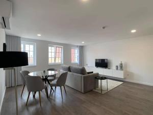 una sala de estar con un sofá y una mesa en PALHOTAS GUEST HOUSE - Apartamento Palhotas, en Braga